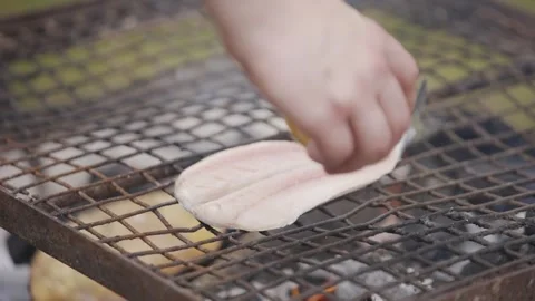 A fish is being cooked on a grill Stock Footage 301629865