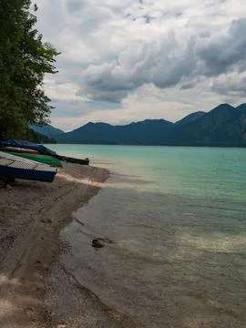 Fish boats stacked on Walchensee coast. Mountain peak of Herzogstand Foto stock