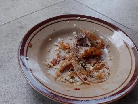 Fish Bones And Leftover Rice On A Plate After Meal Stock Photos