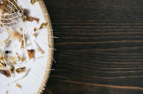 Fish bones on a single white plate. Wooden table background. copy space Stock Photos
