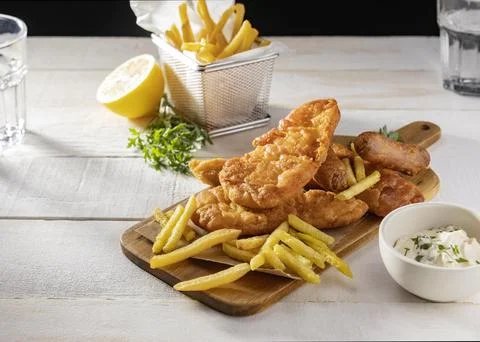 Fish chips chopping board with lemon sauce Stock Photos