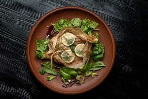 Fish cocked in a wrapper with herbs and sliced lemon. Stock Photos