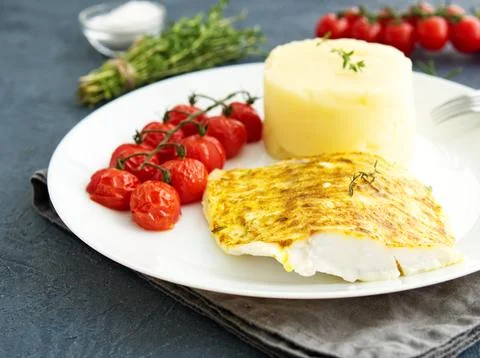 Fish cod baked in oven with mashed potatoes, tomatoes, diet healthy food. D.. Stock Photos
