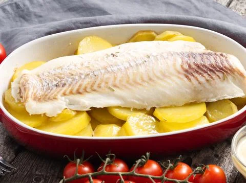 Fish cod baked in the oven with potatoes, diet healthy food. Dark old woode.. Stock Photos