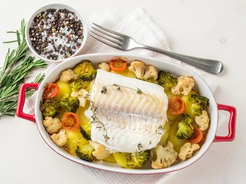 Fish cod baked in the oven with vegetables - healthy diet healthy food. Light Stock Photos