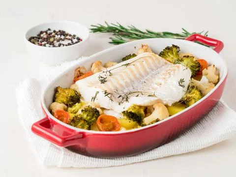 Fish cod baked in the oven with vegetables - healthy diet healthy food. Light Stock Photos