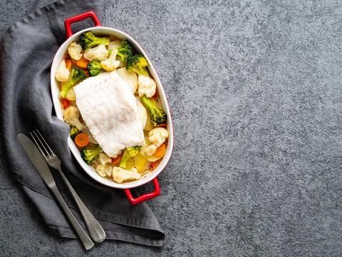 Fish cod baked in the oven with vegetables - healthy diet healthy food. Gray Stock Photos