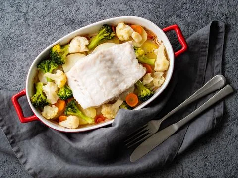 Fish cod baked in the oven with vegetables - healthy diet healthy food. Gray Stock Photos