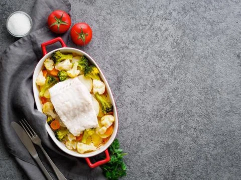 Fish cod baked in the oven with vegetables - healthy diet healthy food. Gray Stock Photos