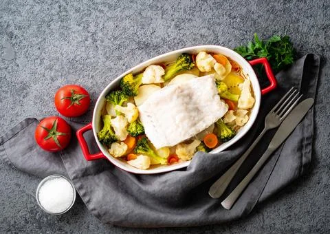 Fish cod baked in the oven with vegetables - healthy diet healthy food. Gray Stock Photos