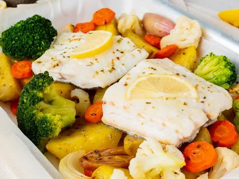Fish cod baked with vegetables - healthy diet healthy food. Light white marbl Stock Photos