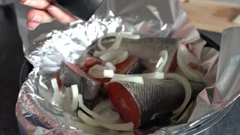 Fish cut into pieces with onion in foil, close-up. Stock Footage 345105363