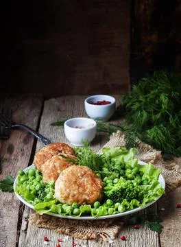 Fish cutlets or meatballs from cod and pike perch with a garnish of green pea Stock Photos