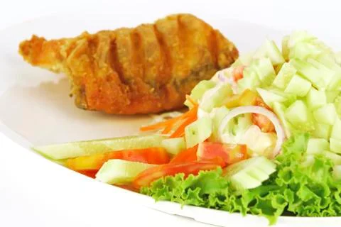 Fish dish - deep fried fish with vegetable salad on white Stock Photos