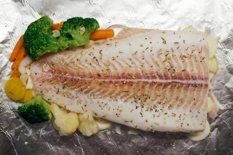 Fish dish - fish with vegetables before baking in foil with carrots and brocc Stock Photos