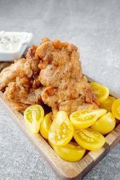The fish dish is fried cod fillet with a creamy sauce and yellow plum tomat.. Stock Photos