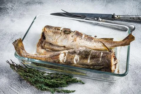 Fish dish - roasted cod fish with herbs in baking dish. White background. Top Stock Photos