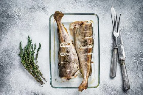 Fish dish - roasted cod fish with herbs in baking dish. White background. Top Stock Photos