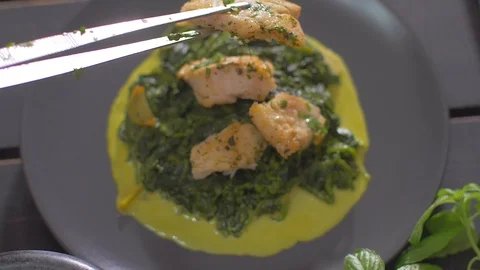 Fish dish with spinach. Place fillets from fish on a spinach couch Stock Footage 111968077