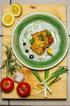 Fish dish - traditional fried cod fish with lemon and tomamos Stock Photos