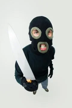 Fish-eye shot of gangster wearing black balaclava with knife in hand Stock Photos