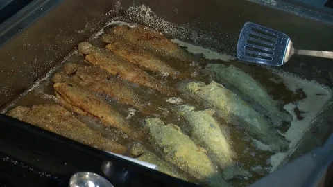 Fish fried in a frying pan until golden brown,Pieces of fresh fish are fried in  Stock Footage 90724109