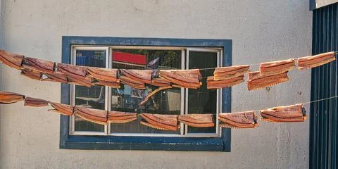 Fish hand on lines outside a fish market drying in the wind and sun Stock Photos