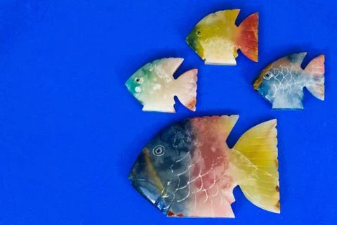 Fish made of stone on a colored background 写真素材