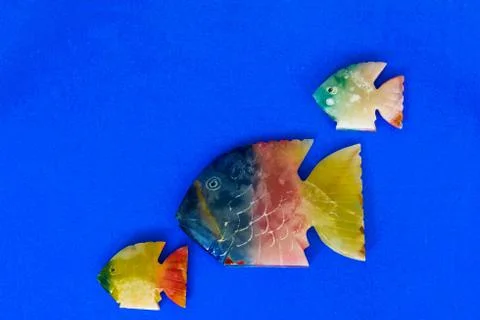 Fish made of stone on a colored background Stock Photos