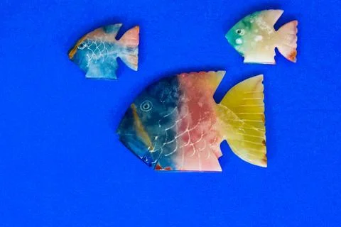 Fish made of stone on a colored background Stock Photos