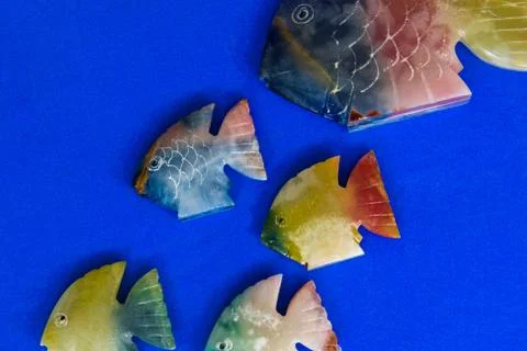 Fish made of stone on a colored background Stock Photos