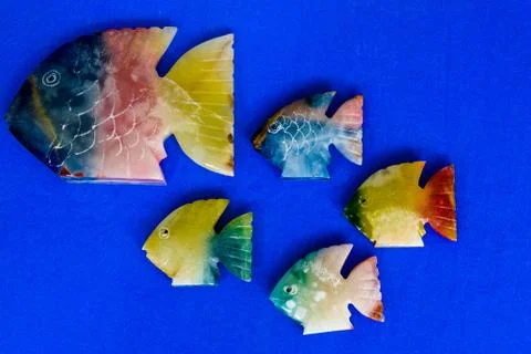 Fish made of stone on a colored background Stock Photos