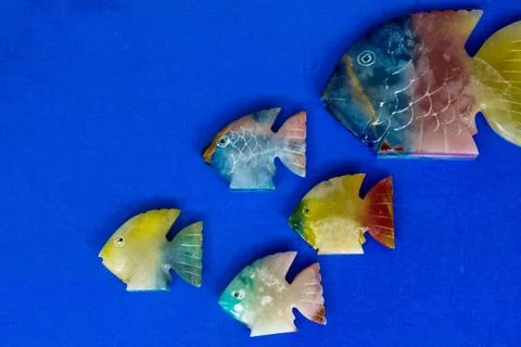 Fish made of stone on a colored background Stock Photos
