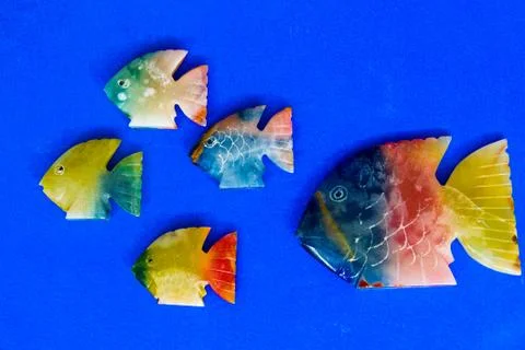 Fish made of stone on a colored background Stock Photos