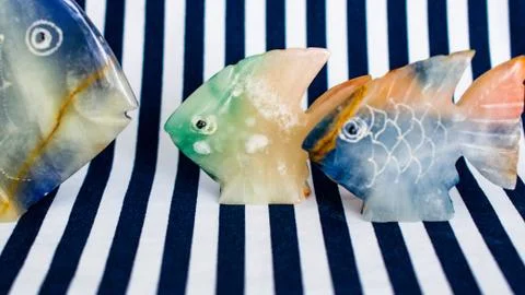 Fish made of stone on a colored background Stock Photos