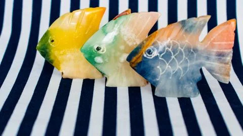 Fish made of stone on a colored background Stock Photos