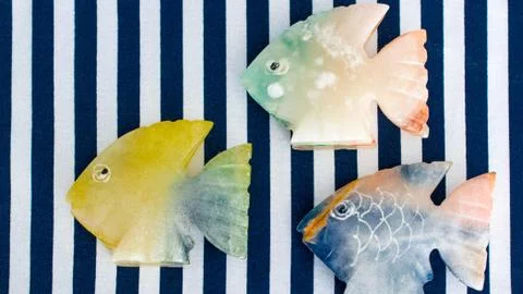 Fish made of stone on a colored background Stock Photos
