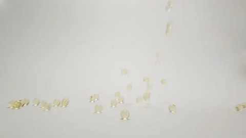 Fish oil capsules falling on white background 库存影片 151900391