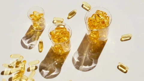 Fish oil  capsules in laboratory  flasks on a white background.Flying capsules Stock Footage 166305949