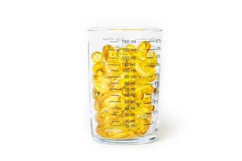 Fish oil capsules is the measurement cup Stock Photos