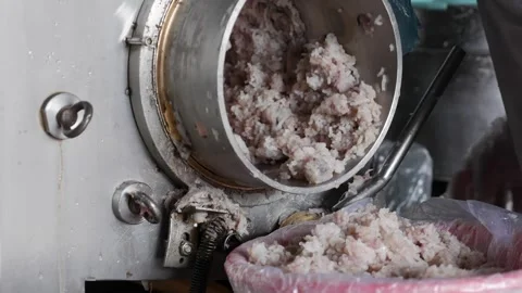 Fish paste moves from a metal machine during food preparation at a local food pr Stock Footage 338001131