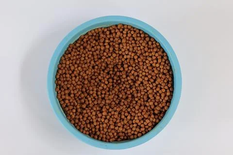 Fish pellets in container isolated on white background. Stock Photos