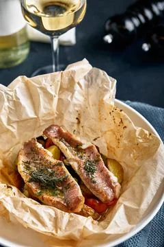 Fish pies and vegetables in craft paper on plate, restaurant giving. Style Stock Photos
