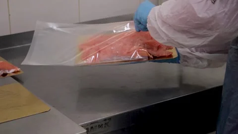 Fish processing worker vacuum packing fish meat Stock Footage 318752860