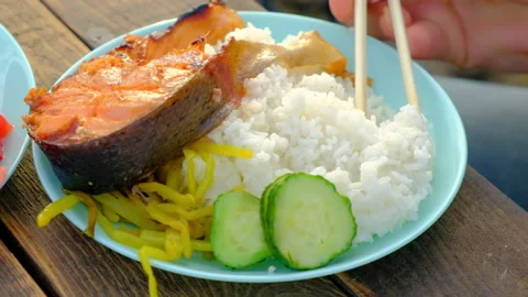 Fish with rice and vegetables close-up, Asian lunch using bamboo sticks Stock Footage 170433818