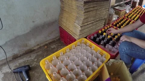 Fish sauce factory empty bottles and woman filling bottles with fish sauce 4k Stock Footage 55861610