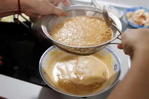 Fish in sauce with shrimp. Step by step preparation. Straining the fumet Stock Photos