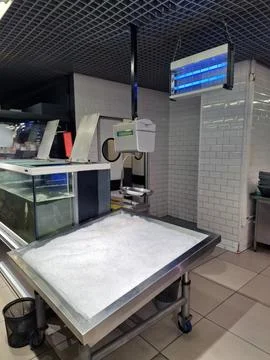 A fish section in a store with an ice cube stand, insect killer, live fish ta Stock Photos