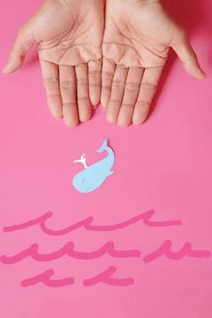 Fish-shaped paper, empty on hand, isolated from pink background. Stock Photos