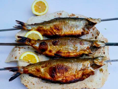 Fish with slices of lemon Stock Photos
